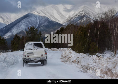 Auto fährt auf der verschneiten Straße in Transbaikalien Nationalpark. Stockfoto