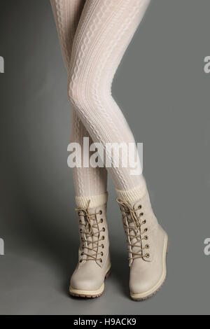 Weibliche Beine in weißen Strumpfhosen und helle winter Stiefel. Stockfoto