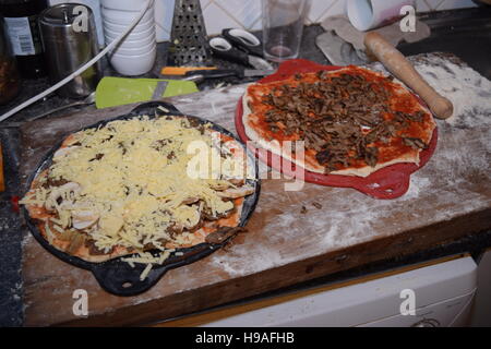 Zwei italienische Pizzen auf einem Holzbrett ungekocht Stockfoto