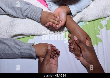 Halten die Hände in einem Quadrat auf einem Bett Stockfoto
