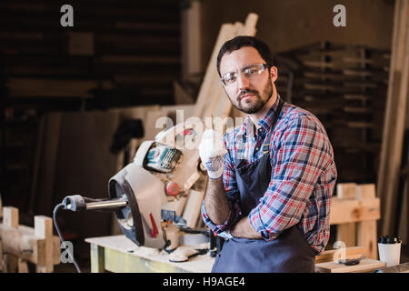 Master vertreibt seine eigenen Produkte. Männliche Schreiner haben eine Idee im Workshop Stift in der Hand halten Stockfoto