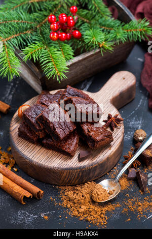 Schokoladenkuchen auf Holzbrett und auf einem Tisch Stockfoto