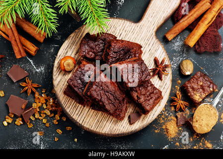 Schokoladenkuchen auf Holzbrett und auf einem Tisch Stockfoto