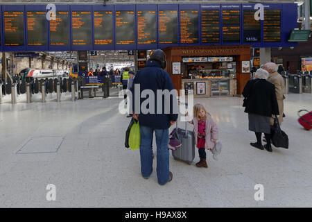 Familie in Glasgow Hauptbahnhof Bahnhof telefonieren suchen Ankünfte board Stockfoto