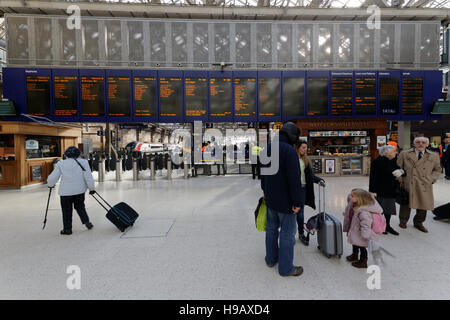 Familie in Glasgow Hauptbahnhof Bahnhof telefonieren suchen Ankünfte board Stockfoto