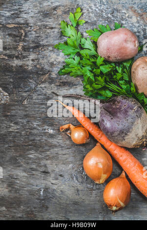 Kartoffeln, Karotten, Zwiebeln, Petersilie, Rüben roh auf rustikalen Hintergrund. Stockfoto