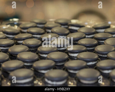 Reihen von handgefertigten schwarzen Baiser französische Macarons mit Sperma auf Handwerker-Lebensmittelmarkt Stockfoto