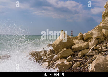 blauer Himmel und aufgewühlte Meer in Eastbourne mit Beachy Head Leuchtturm im Hintergrund Stockfoto