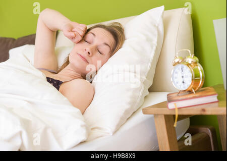 Junge Frau im Bett, nach dem Aufwachen Stockfoto