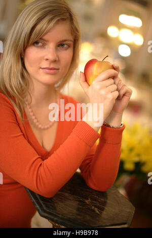 Junge Frau hält einen Apfel Stockfoto