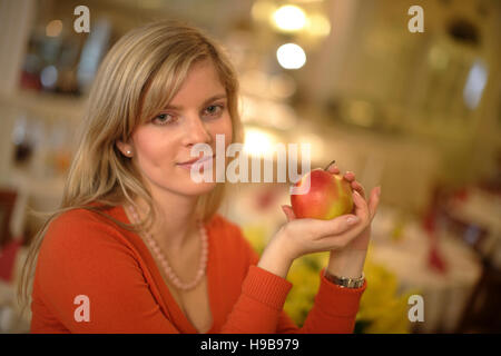 Junge Frau hält einen Apfel Stockfoto