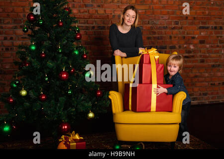 MOM gibt ein Kind Weihnachtsgeschenk Stockfoto