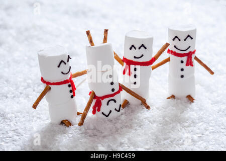 Glücklich lustig Marshmallow Schneemänner auf Schnee Stockfoto