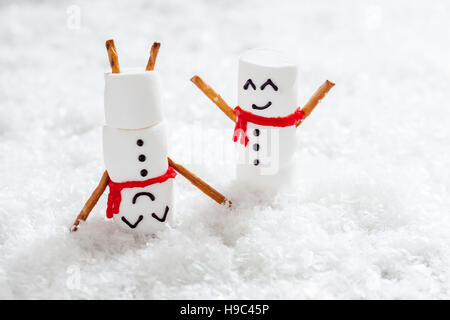 Glücklich lustig Marshmallow Schneemänner auf Schnee Stockfoto