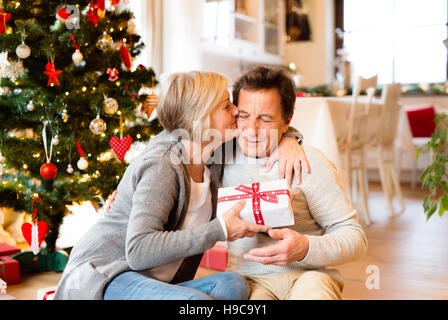 Senior Paar vor Weihnachtsbaum mit Geschenken. Stockfoto