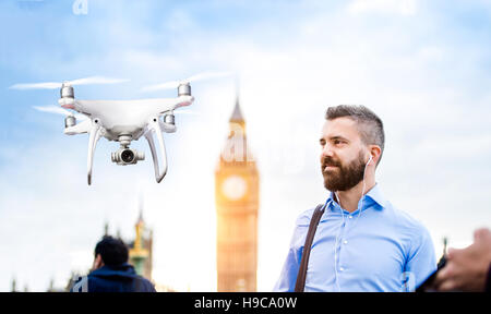 Schwebende Drohne Geschäftsmann in London zu fotografieren Stockfoto
