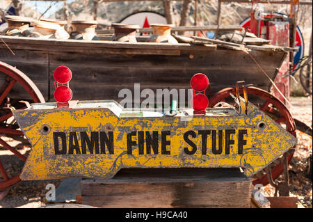 Ein antik gelbes, handgefertigtes, Vintage-Straßenschild mit Pfeil, das Reisenden die Richtung zu Einkaufsmöglichkeiten zeigt Stockfoto