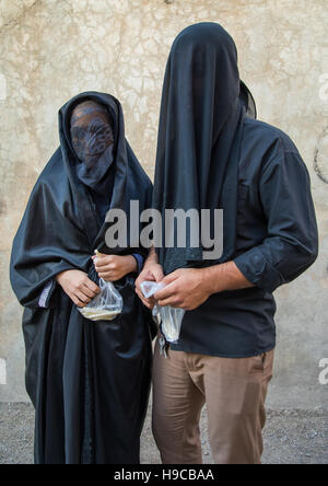 Porträt des iranischen schiitischen Muslime paar mit ihren Gesichtern versteckt durch einen Schleier Trauer Imam Hussein auf Tasua während der Chehel Manbar Zeremonie eines Tages sein Stockfoto