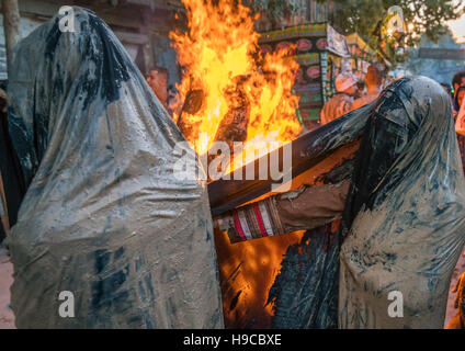 Iranische Schiiten muslimische Frauen versammeln sich um ein Lagerfeuer nach reiben Schlamm auf ihren Tschador während des Kharrah Mali Rituals anlässlich den Aschura-Tag, Lorestan Stockfoto