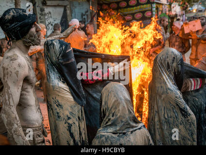 Iranische Schiiten muslimische Frauen versammeln sich um ein Lagerfeuer nach reiben Schlamm auf ihren Tschador während des Kharrah Mali Rituals anlässlich den Aschura-Tag, Lorestan Stockfoto