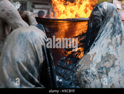 Iranische Schiiten muslimische Frauen versammeln sich um ein Lagerfeuer nach reiben Schlamm auf ihren Tschador während des Kharrah Mali Rituals anlässlich den Aschura-Tag, Lorestan Stockfoto