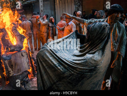 Iranische Schiiten muslimische Männer und Frauen versammeln sich um ein Lagerfeuer nach reiben Schlamm auf ihre Kleidung während des Kharrah Mali Rituals anlässlich den Aschura-Tag, Stockfoto