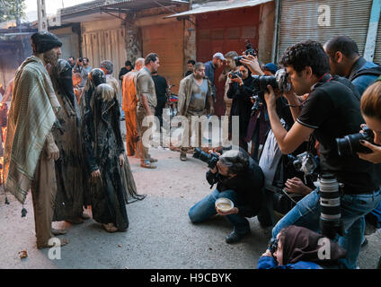 Fotografen fotografieren der iranischen schiitischen Muslime, die Lagerfeuer versammeln sich nach Schlamm auf ihre Kleidung während des Kharrah Mali Rituals zu reiben Stockfoto