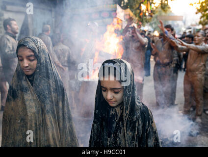 Iranische Schiiten muslimische Männer und Frauen versammeln sich um ein Lagerfeuer nach reiben Schlamm auf ihre Kleidung während des Kharrah Mali Rituals anlässlich den Aschura-Tag, Stockfoto