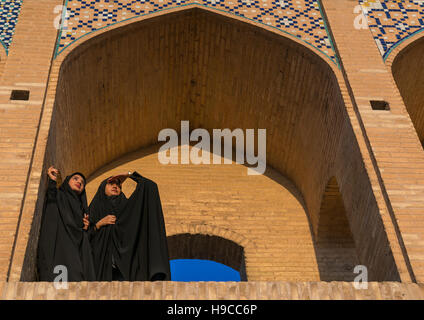 Zwei junge verschleierte Frauen auf Khaju Brücke Pol-e Khaju wegsehen, Provinz Isfahan, Isfahan, Iran Stockfoto