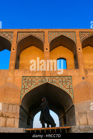 Verschleierter Iranerin vorbei an Khaju-Brücke Pol-e Khaju, Provinz Isfahan, Isfahan, Iran Stockfoto