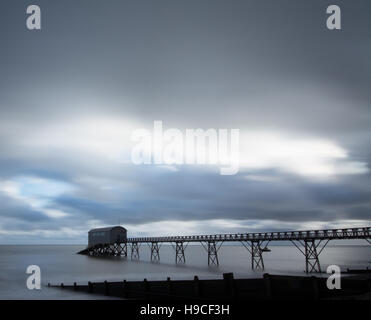 Lange Exposition von Selsey Rettungsboot Station in West Sussex, UK, mit dramatischen Himmel. Moody abstrakt. Stockfoto