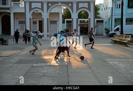 Silhouetten von kubanischen Jugendliche Fußball auf der Straße spielen, wenn die Sonne untergeht dahinter in Cienfuegos Kuba Stockfoto