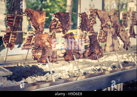 Asado, traditionellen Barbecue-Gericht in Argentinien, gebratenes Fleisch Rindfleisch gekocht auf einem vertikalen Grill um Feuer gelegt. Vintage-look Stockfoto