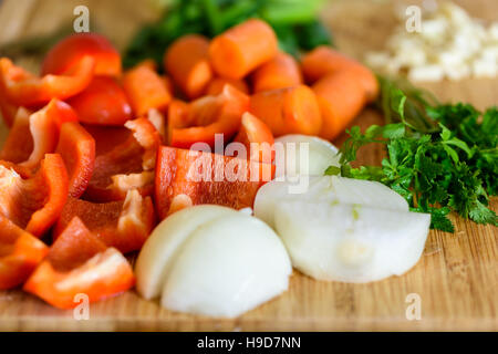 Zwiebel, Karotten, Paprika, Knoblauch und Petersilie rohes Gemüse Zutaten auf Holz Stockfoto