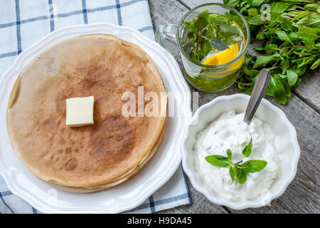 Russische dünne Pfannkuchen mit Butter, Käse, Marmelade, Minze auf einer Serviette auf einem hölzernen Hintergrund.  Liebe für ein gesunde Süße Food Konzept Stockfoto