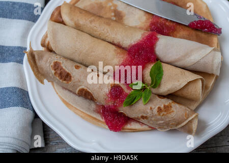 Russische dünne Pfannkuchen mit Butter, Käse, Marmelade, Minze auf einer Serviette auf einem hölzernen Hintergrund.  Liebe für ein gesunde Süße Food Konzept Stockfoto