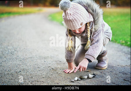 Kind-Punkte auf den Steinen mit Finger. Horizontal im Freien gedreht Stockfoto