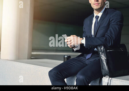 Mann mit grauem Handy in seinen Händen. Horizontal im Freien gedreht Stockfoto