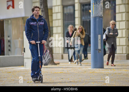 Mann auf einem Roller durch die Straßen von Wien, Österreich Stockfoto