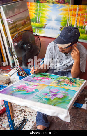 Ein Mann Malerei Batik in Malakka, der Weltkulturerbe Stadt flankieren die Straße von Malakka auf der Halbinsel Malaysia. Stockfoto