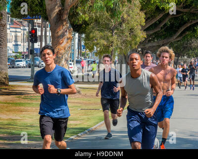 Kaukasischen und afrikanischen amerikanischen Highschool Sportler halten Sie sich fit durch laufen entlang der Ocean Avenue in Santa Monica, Kalifornien. Stockfoto