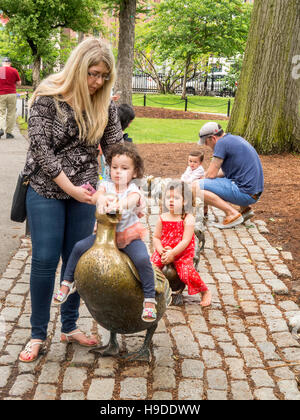 Kinder spielen am Bronze-Skulpturen von einer Ente und Entenküken von Nancy Schon in Erinnerung an das Buch "Make Way for Entenküken" von Robert McCloskey geschaffen. Stockfoto