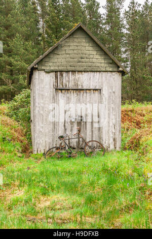 Alten rostigen Fahrrad gelehnt rustikale Scheune/Nebengebäude, Glen Etive, Highlands von Schottland, UK. Stockfoto