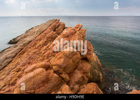 Felsige Ufer von Mineralien, die der roten Farbe, der Ägäis, in der Nähe von Athen, Griechenland. Stockfoto