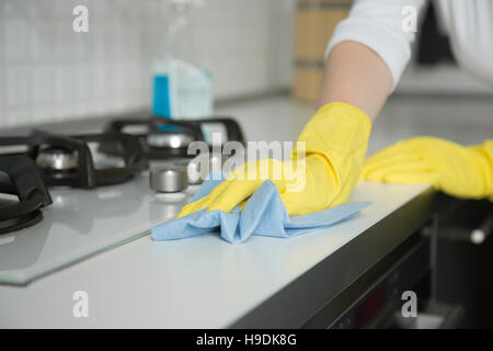 Nahaufnahme der weiblichen Hände in Gummihandschuhe, die Reinigung des Herds Stockfoto