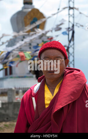 Ein Lama steht vor einer buddhistischen Stupa in abgelegenen Tawang in Indien. Stockfoto