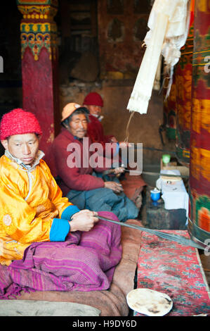 Mönche im Kloster Tawang spin große Gebetsmühlen beim Singen buddhistische Gebete im abgelegenen Tal Tawang, Indien. Stockfoto