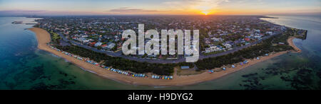 Aerial Panorama der Sonnenaufgang über Brighton Vorort, mit legendären Strandhütten, Häuser und das Meer. Melbourne, Victoria, Australien Stockfoto