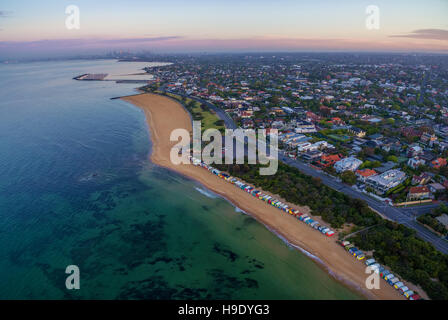 Luftaufnahme des Sonnenaufgangs an Brighton Beach Küste mit Strand-Boxen und CBD in der Ferne. Melbourne, Victoria, Australien. Stockfoto