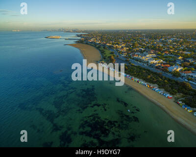 Luftaufnahme des Sonnenaufgangs an Brighton Beach Küste mit Strand-Boxen und CBD in der Ferne. Melbourne, Victoria, Australien. Stockfoto